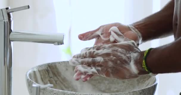 African man washing hands over bathroom sink, close up view — Stock Video