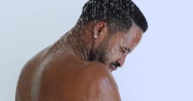 Çekici, mutlu, seksi, çıplak, Afrikalı bir adam duş alıyor.