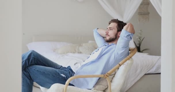 Jeune homme détendu paresseux refroidissant dans une chaise confortable à la maison — Video