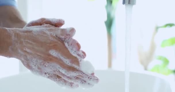 Jongeman wassen mannelijke handen met zeep onder water, close-up — Stockvideo