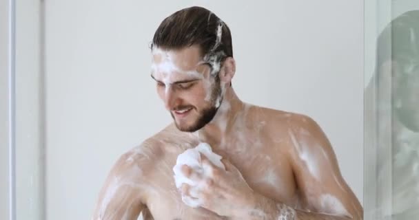 Smiling sexy young adult man taking morning shower — Stock Video