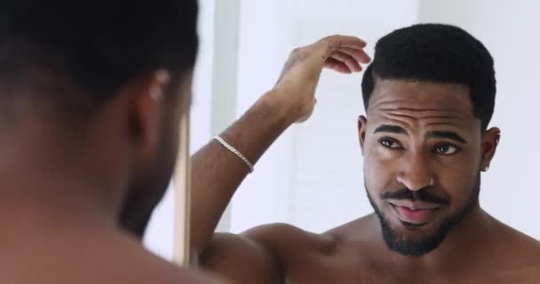 Szczęśliwy pewny afro amerykański facet robi fryzurę patrząc w lustro — Wideo stockowe