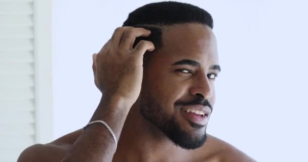 Confident shirtless african hipster man grooming looking at camera — Stock Video