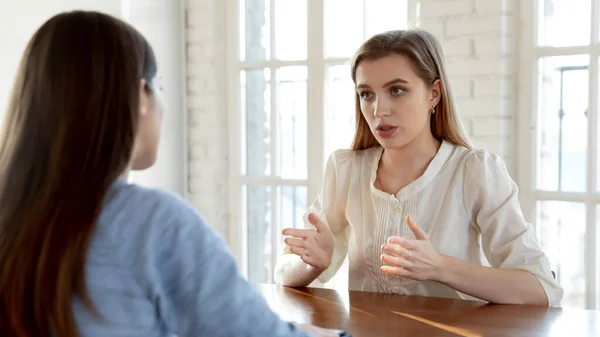 Confident female candidate talk with employer at interview