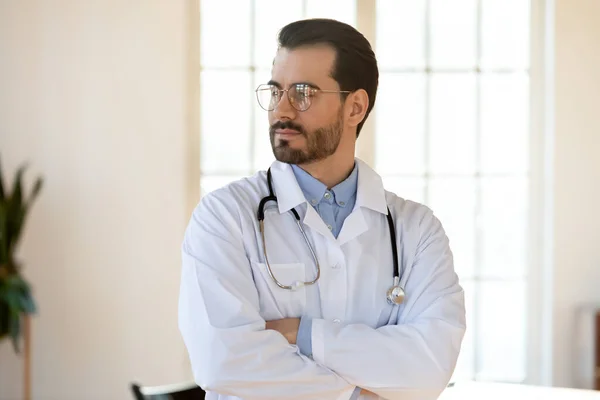 Pensive male doctor look in distance thinking or visualizing