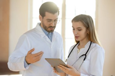 Çeşitli doktorlar anesteziyi tablet cihazıyla tartışıyor.