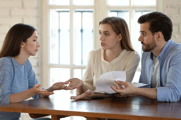 Pareja enojada discute con agente inmobiliario sobre las reglas del contrato — Foto de Stock