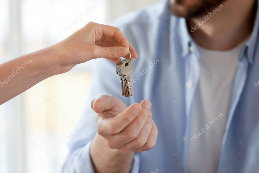 Close up of relator give keys to male client