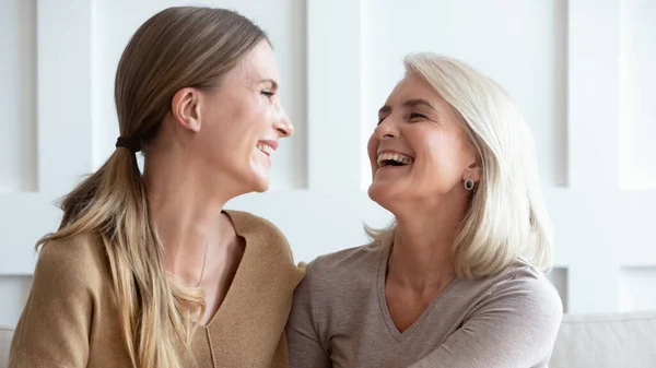 Smiling senior mom and adult daughter laugh — Stock Photo, Image