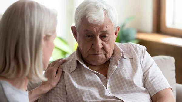 Caring mature woman comfort support upset elderly man