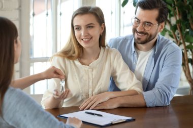 Emlakçı heyecanlı çiftin anahtarlarını verdi.