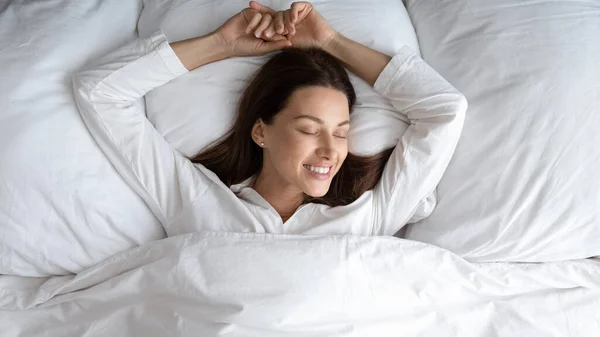 Top melihat wanita berbaring di tempat tidur terbangun setelah tidur malam — Stok Foto