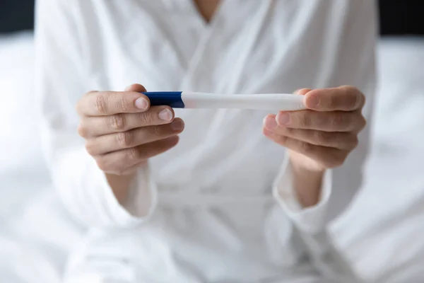 Closeup image female hands holding positive negative result pregnancy test — Stock Photo, Image