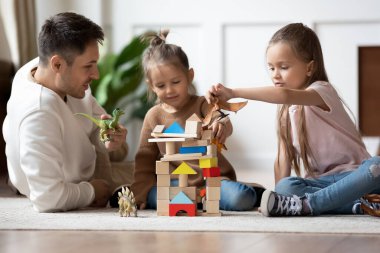 Mutlu baba sıcak zeminde oynayan iki kızıyla oynuyor.