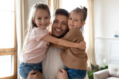 Kafa resmi, gülümseyen baba kucağında küçük kızları.