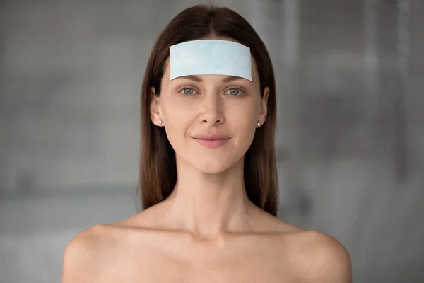 Headshot portrait naked woman apply facial patches forehead wrinkles smoothers — Stock Photo, Image