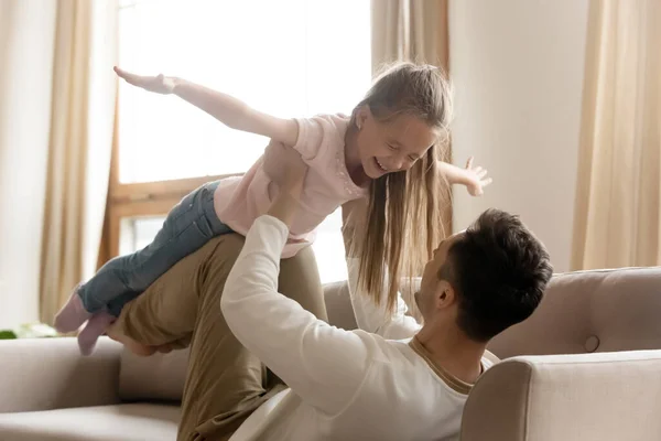 Щасливий батько грає з маленькою донькою на дивані вдома — стокове фото