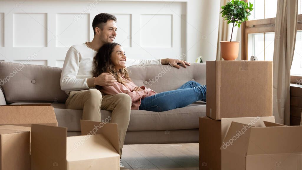 Happy young couple relaxing on couch on moving day