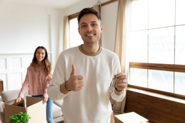 Yeni evin anahtarlarını gösteren gülümseyen koca portresi.