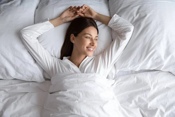 Kobieta leżąca samotnie w wygodnym łóżku po nocy snu — Zdjęcie stockowe