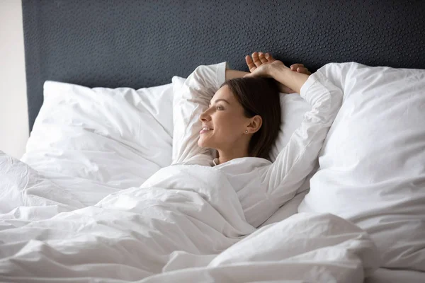 Wanita bangun berbaring di tempat tidur bermimpi menikmati hari baru — Stok Foto