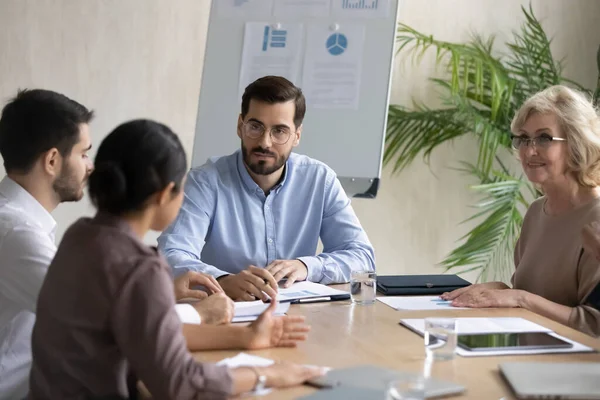 Serieuze zakenman luisteren Indiase werknemer over project zitten aan tafel. — Stockfoto