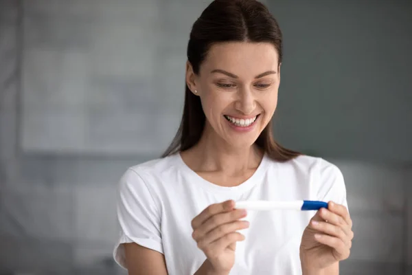 35s woman holding pregnancy test saw two stripes feels happy — Stock Photo, Image