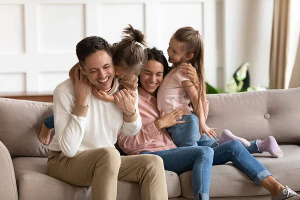 Happy mother and father hugging with two little daughters — Stock Photo, Image