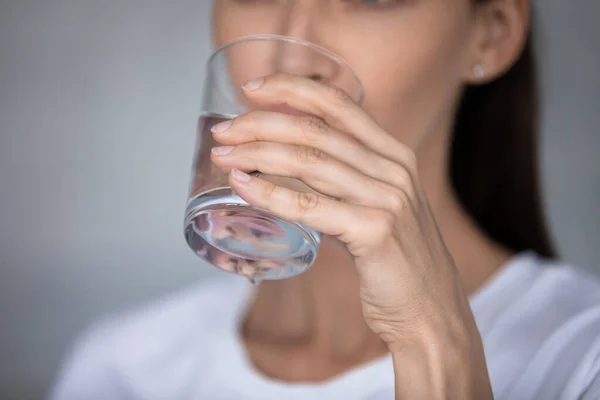 Primo piano concentrarsi sulla mano femminile che tiene il bicchiere di acqua potabile — Foto Stock