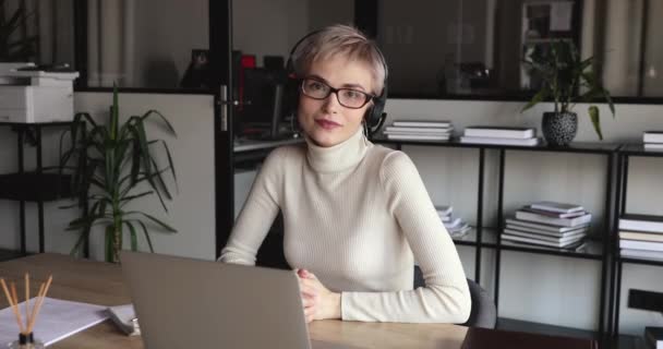 Femme manager souriante portant un casque regardant la caméra sur le lieu de travail — Video