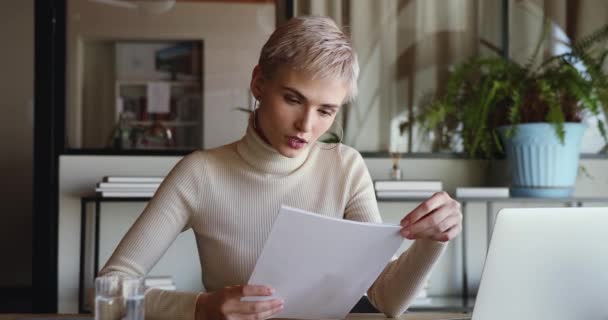 Emocionada joven trabajadora leyendo documentos financieros celebrando buenas noticias — Vídeo de stock