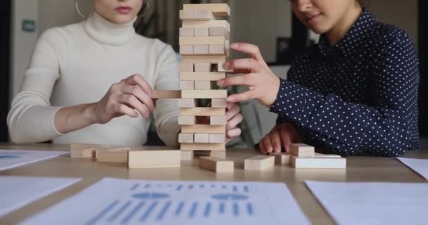 Female partners playing jenga game on office table, close up — Stock Video