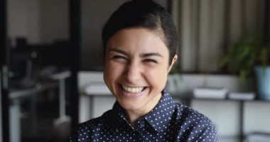 Neşeli, komik, yetişkin Hintli kadın kameraya bakıp gülüyor.