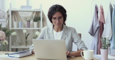 Coşkulu genç moda tasarımcısı başarıyı kutlayan dizüstü bilgisayara bakıyor