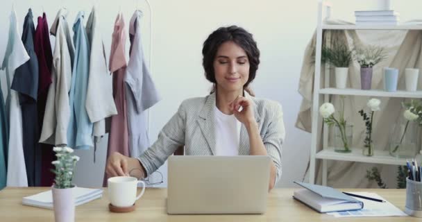 Smiling fashion designer taking break at workplace finishing laptop work — Stok Video