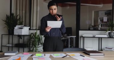 Profesyonel Hintli işçi ofiste evrak işi yaparken ses mesajı kaydediyor.