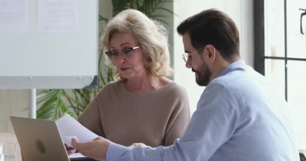 Ältere weibliche Chefin mittleren Alters diskutiert mit Mitarbeiter über Daten. — Stockvideo