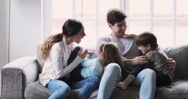 Mutlu genç evli çift, küçük şirin çocukları gıdıklıyor..