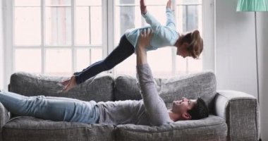 Güçlü oyuncu baba, gülen küçük kızı kaldırıyor..