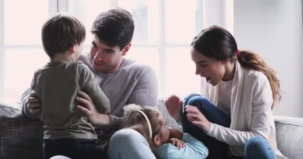 Lachende Eltern amüsieren sich am Wochenende mit überglücklichen Kindern. — Stockvideo