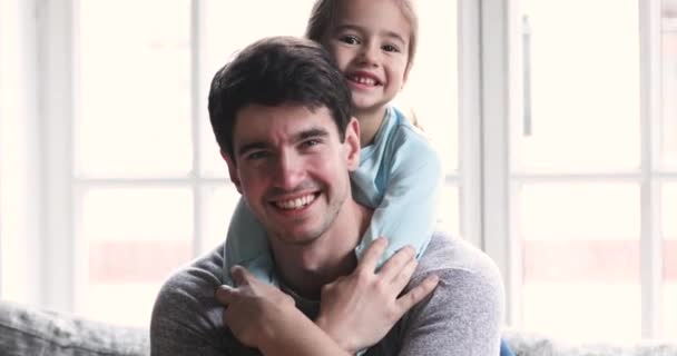 Όμορφο κοριτσάκι αγκαλιά πατέρα, κοιτάζοντας την κάμερα. — Αρχείο Βίντεο