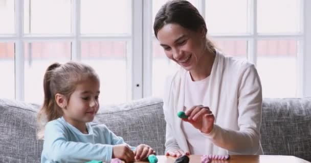 Menina pré-escolar brincando com plasticina com a mamãe . — Vídeo de Stock