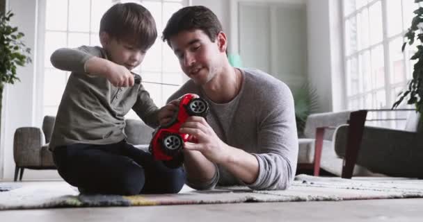 Focused small child boy learning fixing truck with father. — Stock Video