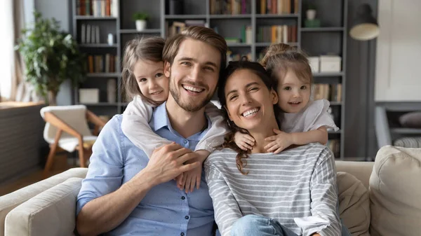 Portret van jonge familie met kleine dochters thuis — Stockfoto