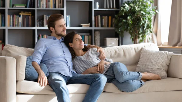 Jovem casal relaxar no sofá confortável em casa — Fotografia de Stock