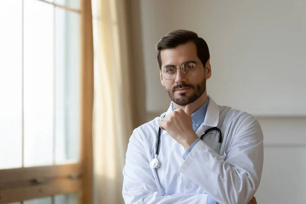 Portrét seriózního mužského lékaře pózujícího v nemocnici — Stock fotografie
