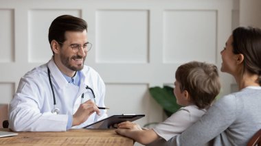 Erkek doktor hastanedeki küçük çocuğu muayene ediyor.