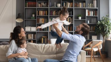 Neşeli ebeveynler küçük kızlarıyla eğleniyor.