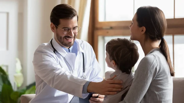 Caring male doctor cheer little boy patient a checkup — Stock Photo, Image