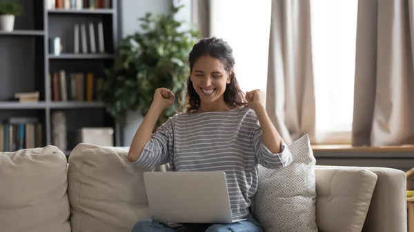 Gelukkig jong vrouw triomf lezen goed nieuws op laptop — Stockfoto